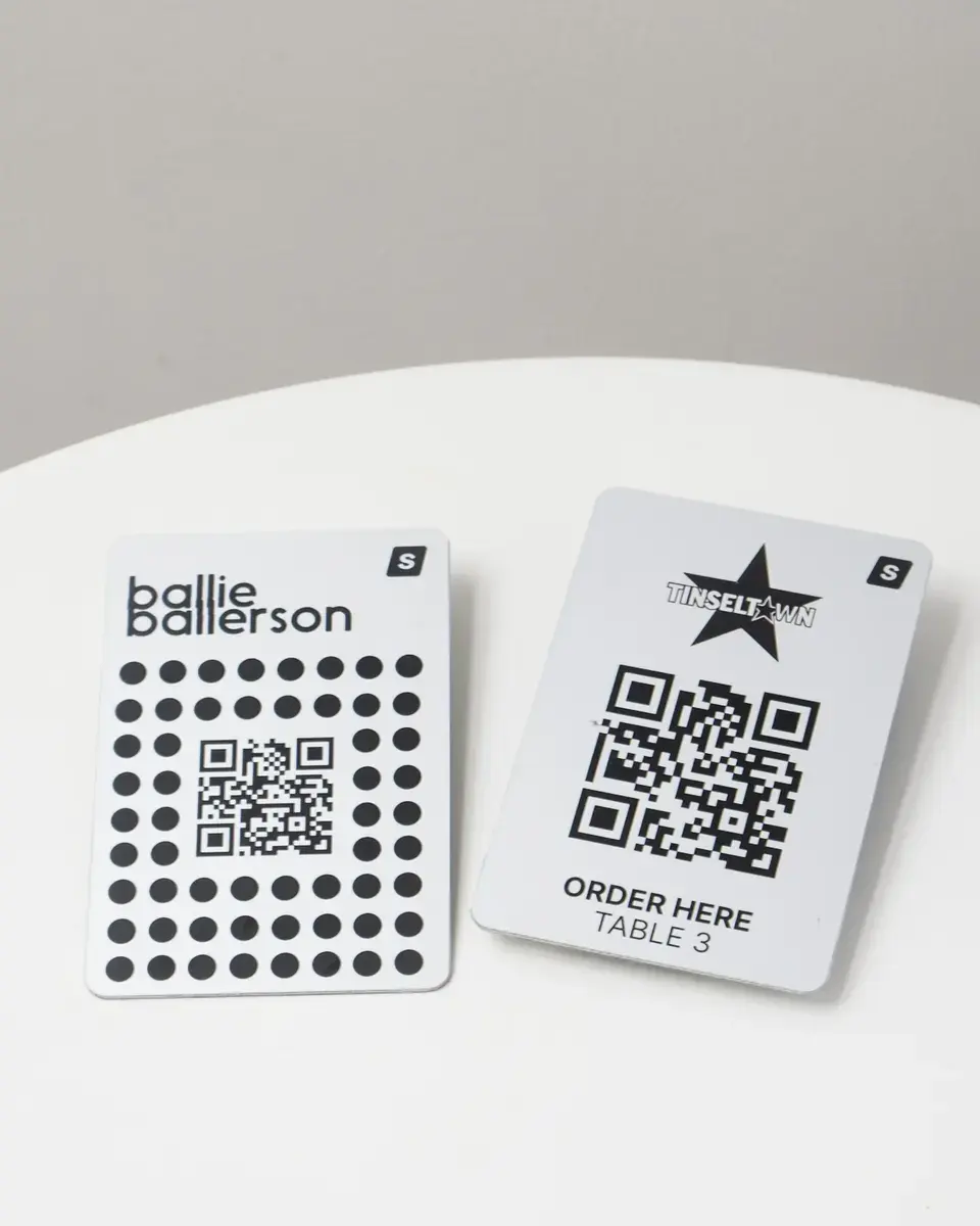 Two brushed silver aluminium plates for Ballie Ballerson, each with a QR code