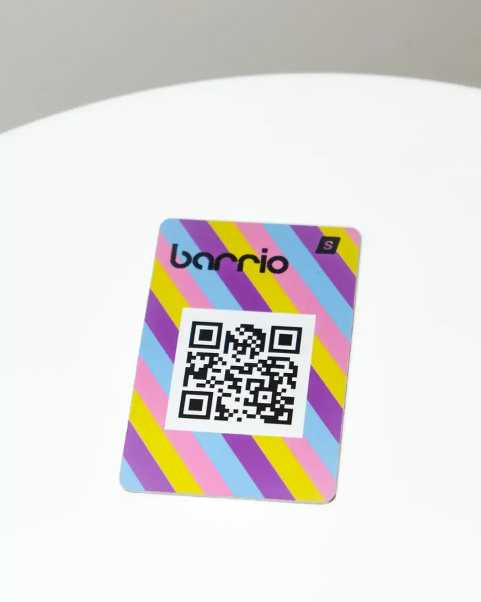 Aluminium plate for Barrio printed with bright diagonal stripes around a QR code