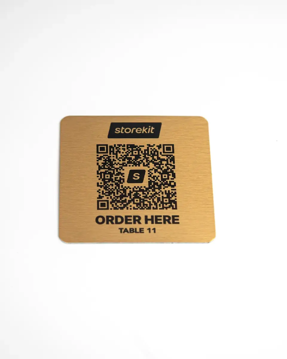 Small brushed gold aluminium square with a QR code and 'Order here'