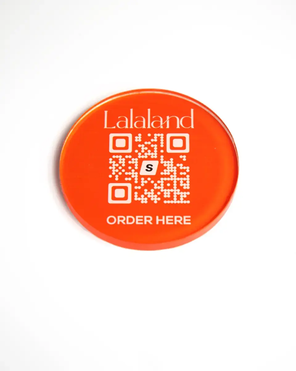 Orange Perspex disc for Lalaland with a QR code and 'Order here'