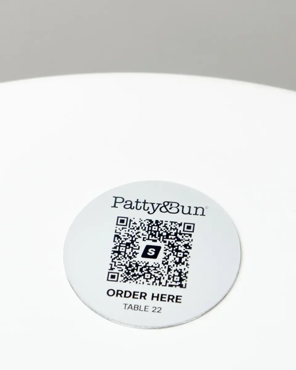 Brushed silver aluminium disc for Patty & Bun with a QR code to order