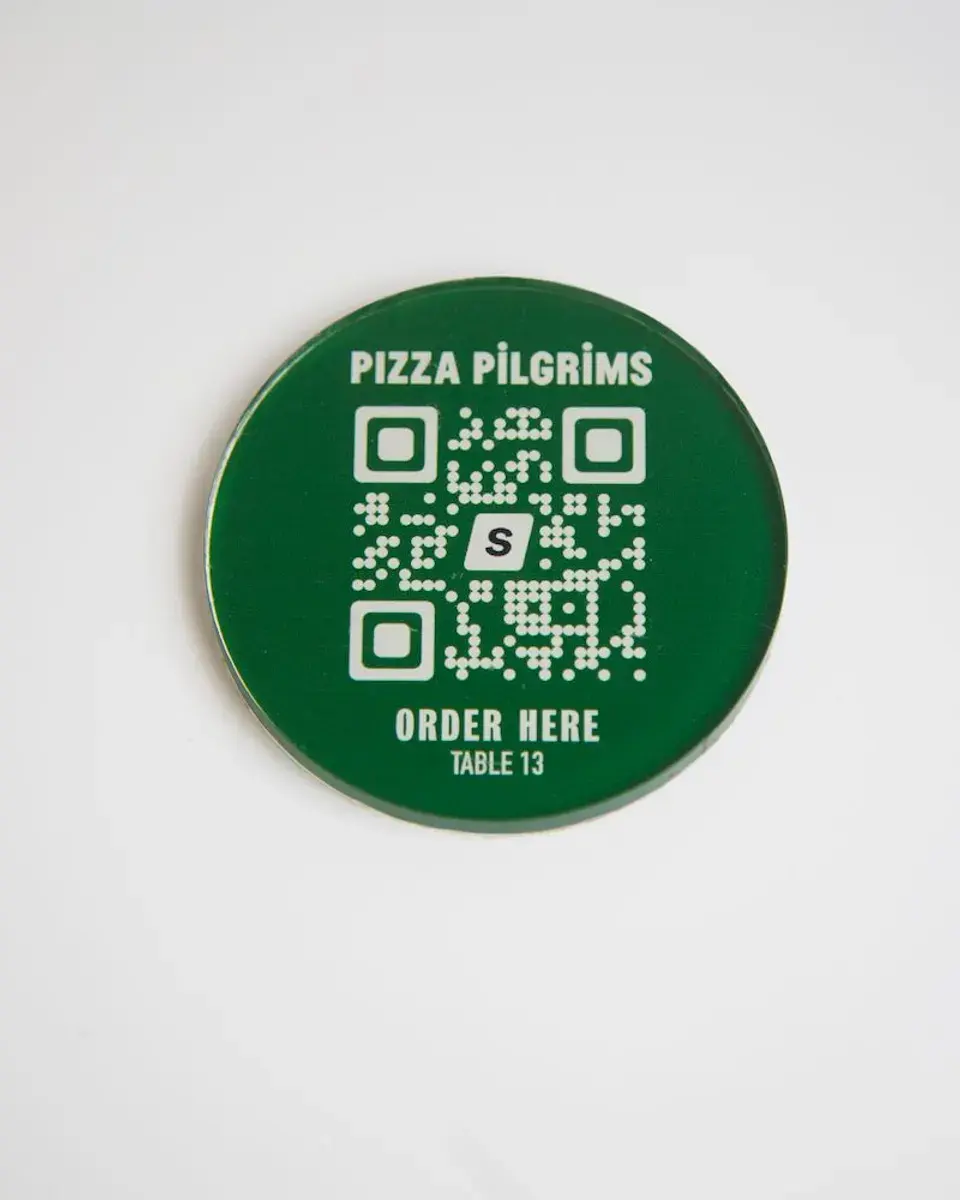 Dark green Perspex disc for Pizza Pilgrims with a QR code to order