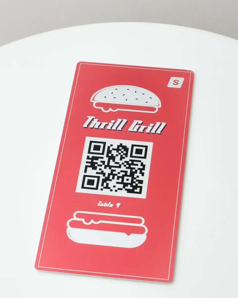Red aluminium plate for Thrill Grill with burger artwork around a QR code